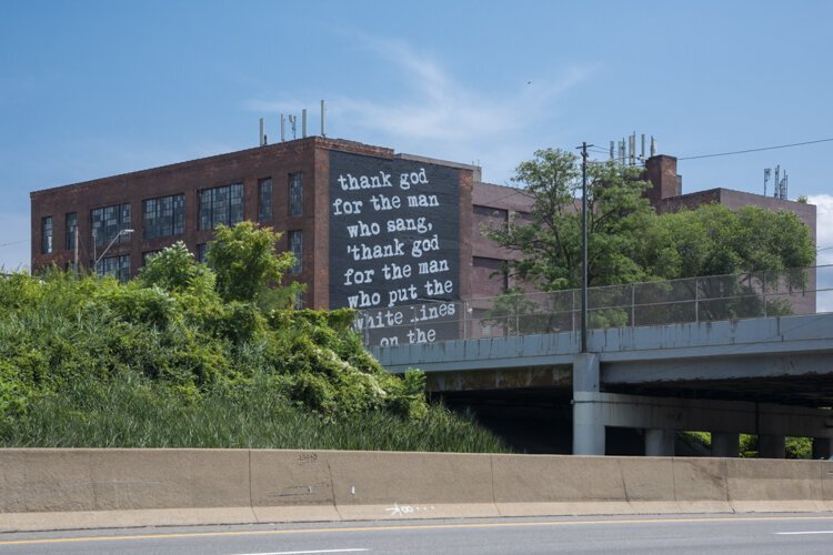 2630 Payne Avenue — four-story brick warehouse with the WRDSMTH Michael Stanley tribute mural facing I-90 in Cleveland.